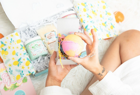 woman opening bath product gift box for relaxation